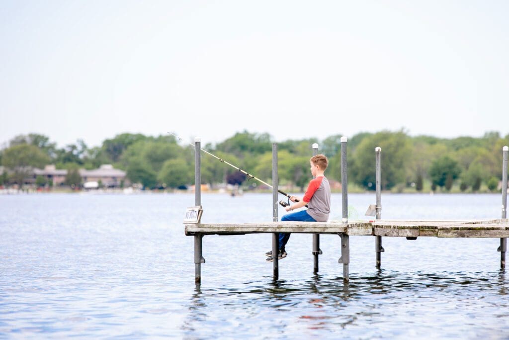 A young boy fishes from a dock on Delavan Lake.
