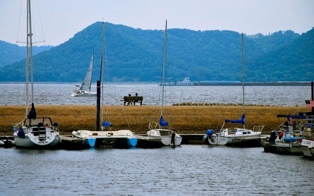 A couple sits on a bench looking out onto Lake Pepin.