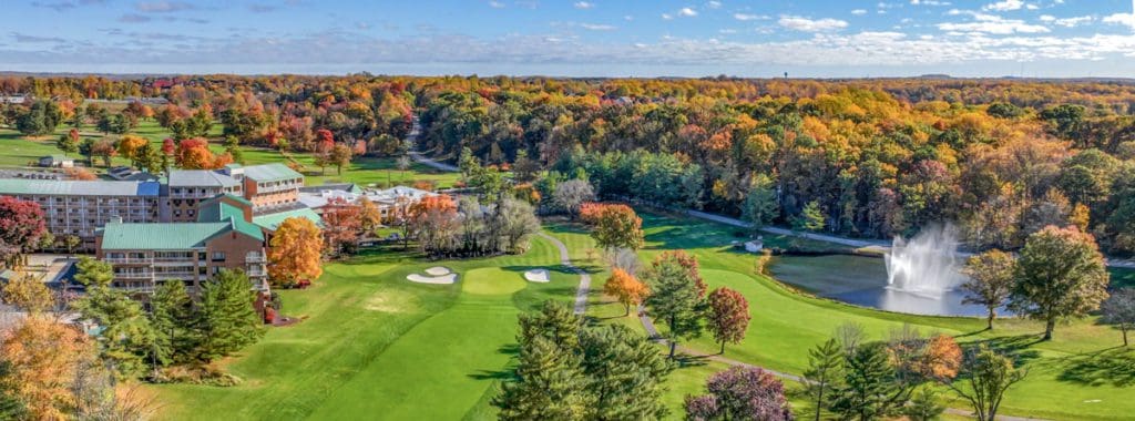 An aerial view of the sprawling property of Turf Valley Resort, filled with a forest of fall colors.