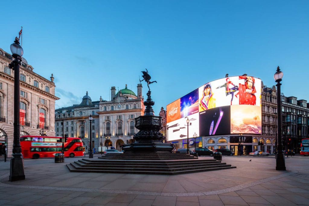 Cars drive around the loop at Piccadilly Circus in Soho, one of the best neighborhoods in London for families.