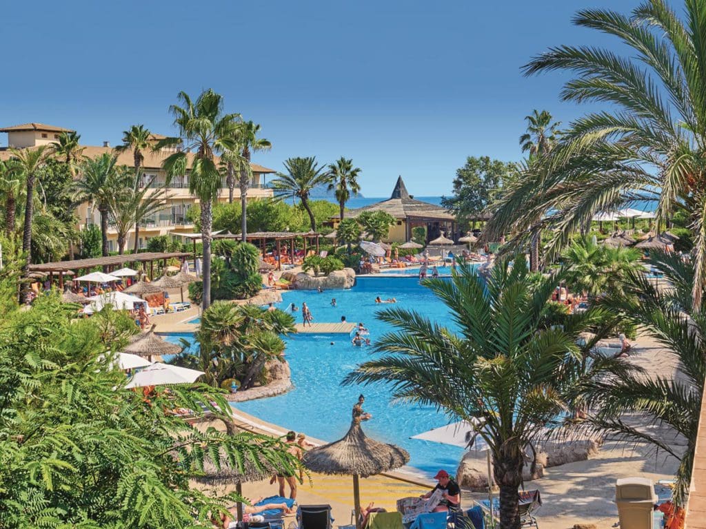 Several people enjoy a sunny dat at the pool, while staying at Allsun Eden Playa.
