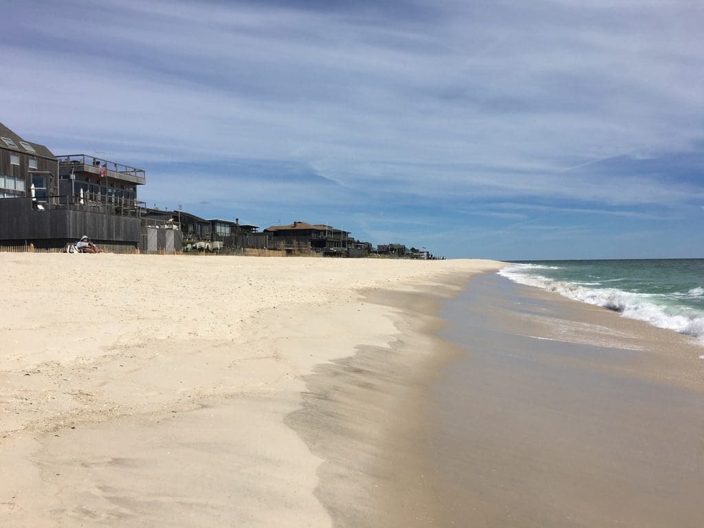 A sandy shoreline of Fire Island, a family-friendly East Coast town with sandy beaches and beach houses.