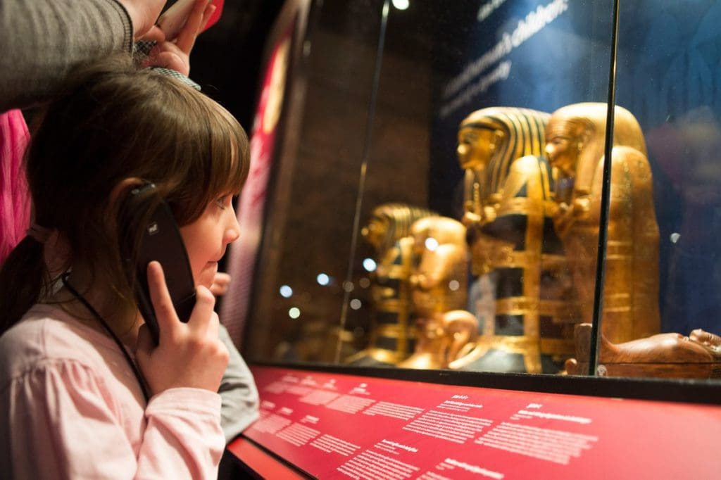 A young girl listens to an audio tour at COSI - Center of Science and Industry.