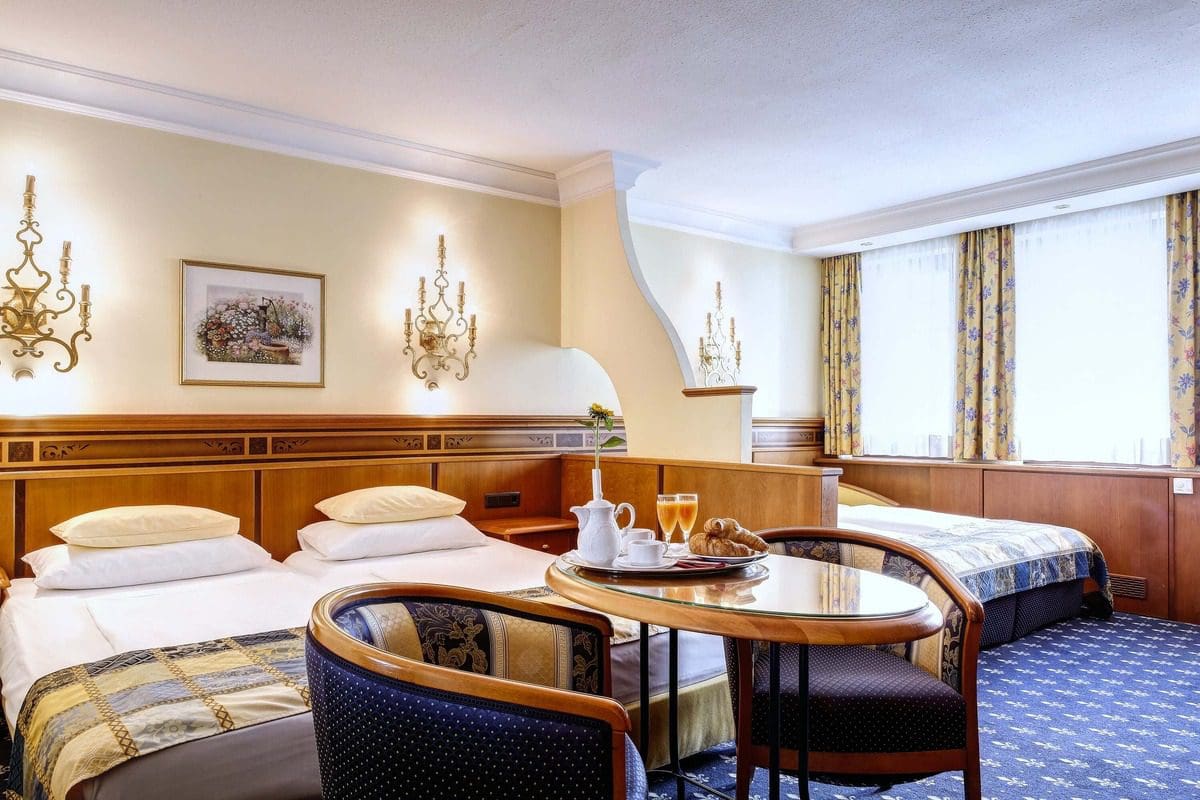 Inside a family suite, showcasing multiple sleeping areas, at Hotel Mondschein.