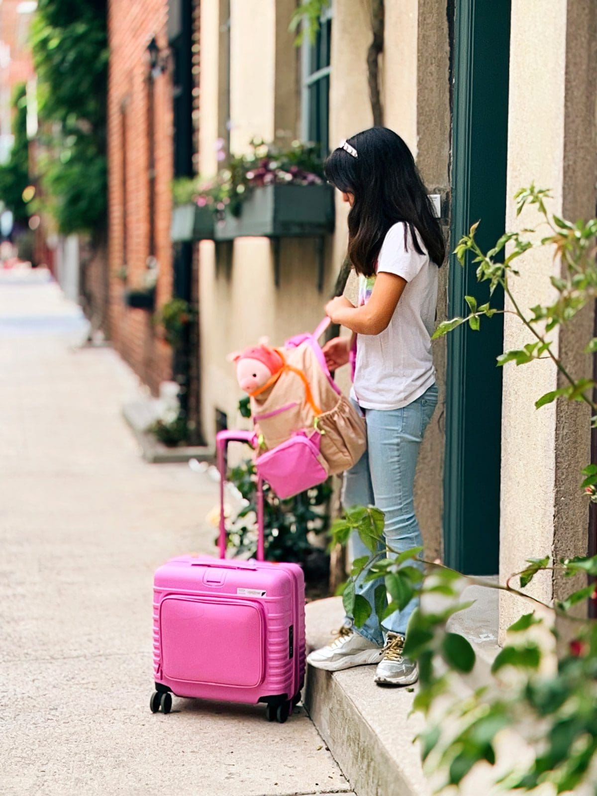 A young girl leaves a hotel with her Kids Roller and backpack.