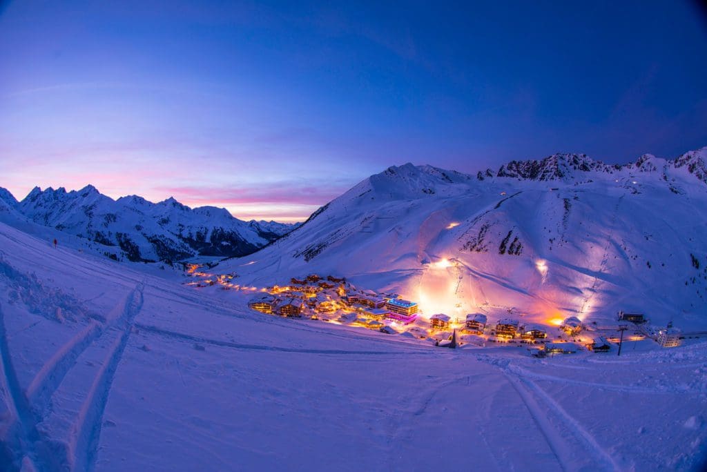 An aerial view of the cozy town of Kühtai, nestled in the Austrian Alps at night.