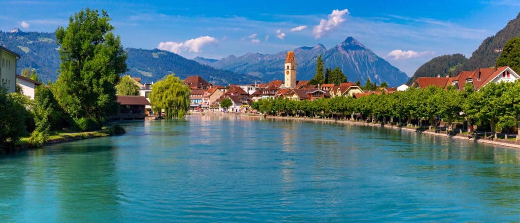 The lake in Interlaken, with the city in the distance, a great stop on any Switzerland itinerary with kids.