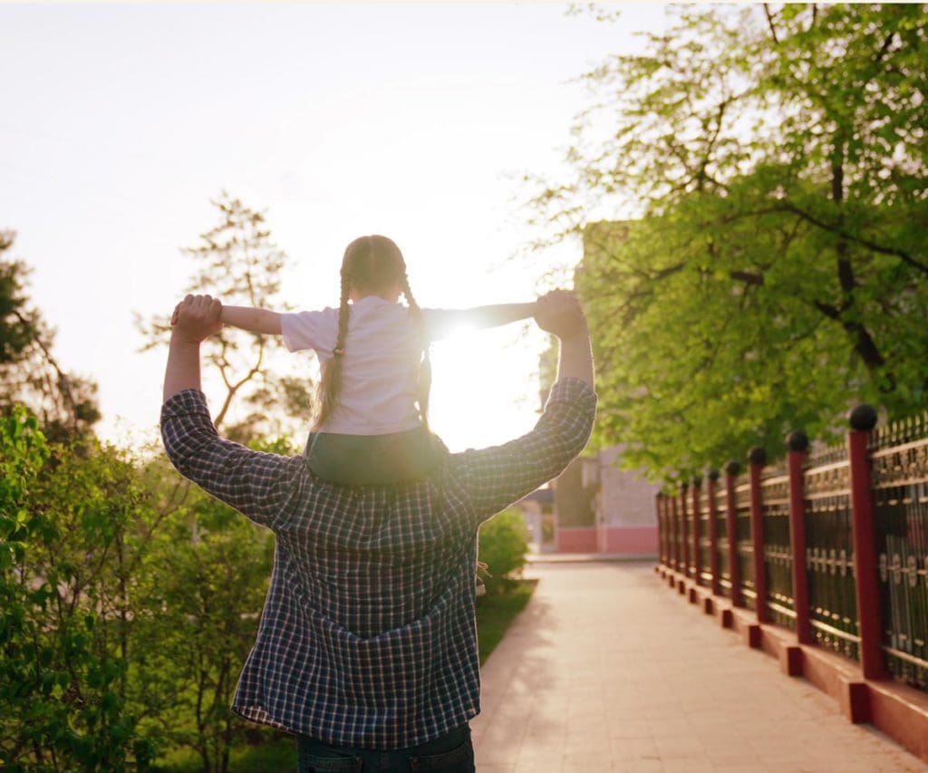 A girl atop her father's shoulders while exploring Ocean City.