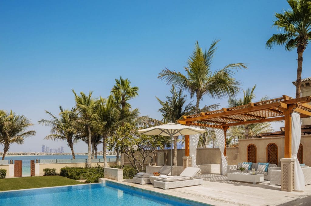 Lush beach cabanas along the side of a pool at One&Only The Palm.