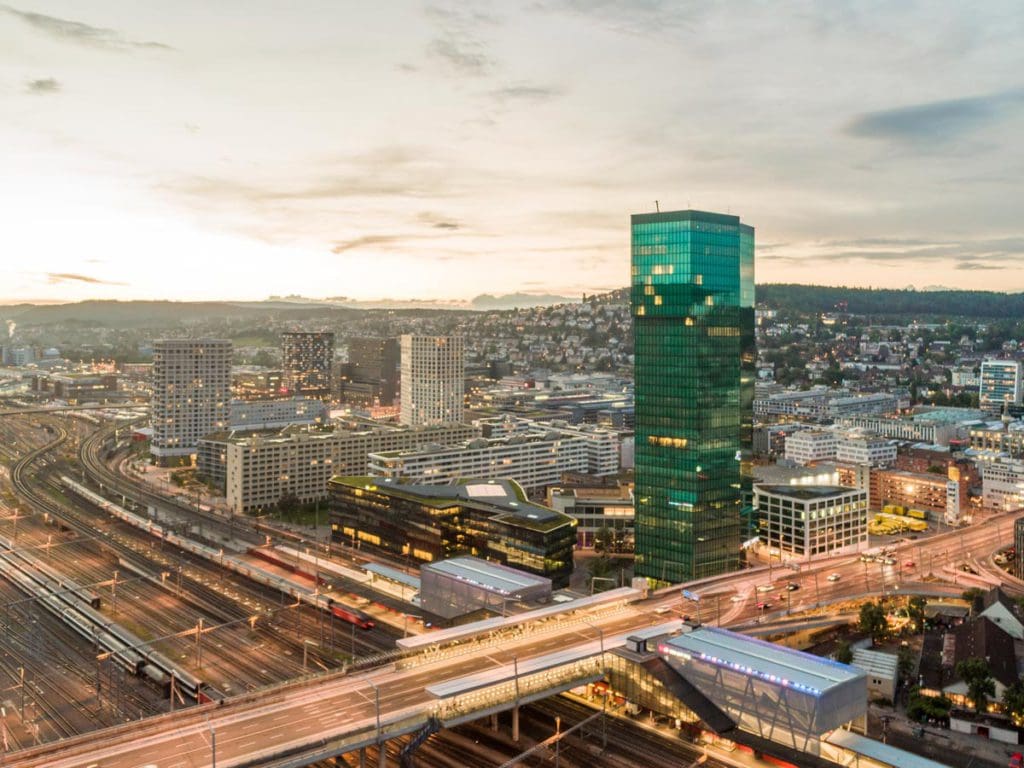 The exterior of Sheraton Hotel Zurich, lit up at dusk.