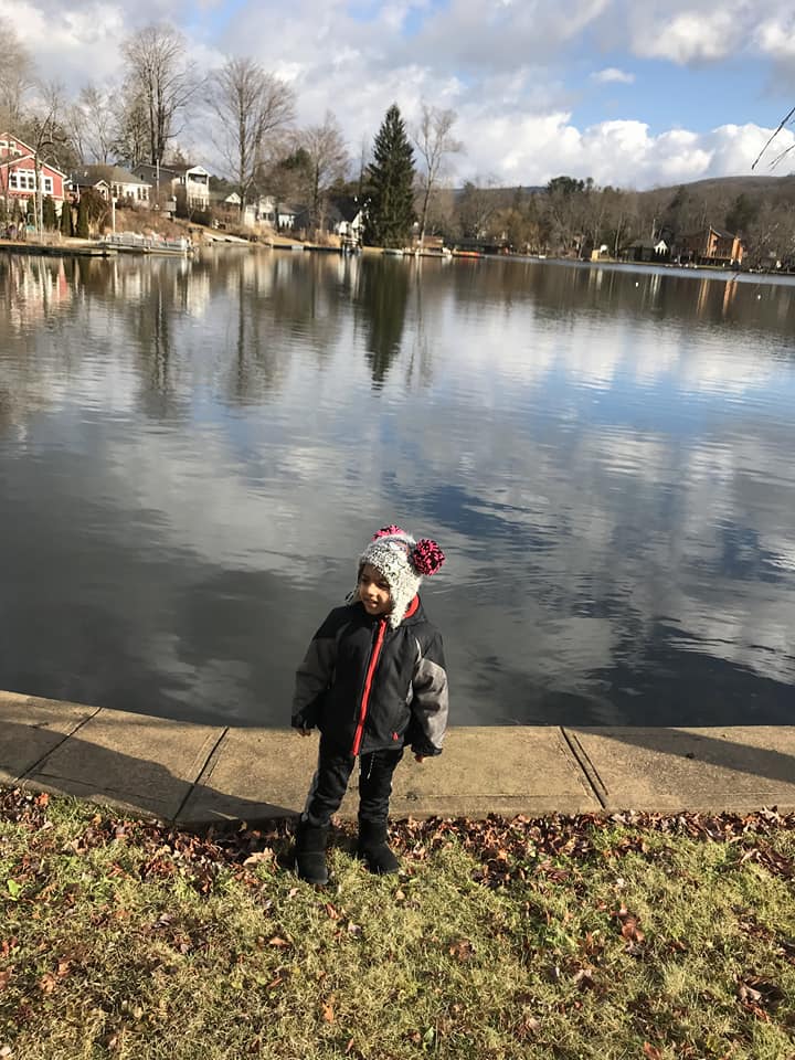 A young boy stands at the edge of Greenwood Lake, one of the best lakes in New York State for families.