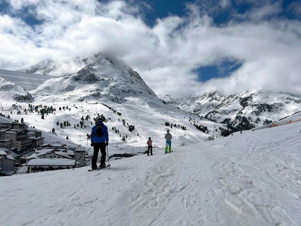 A dad and his two kids skis along a trail in Kühtai.