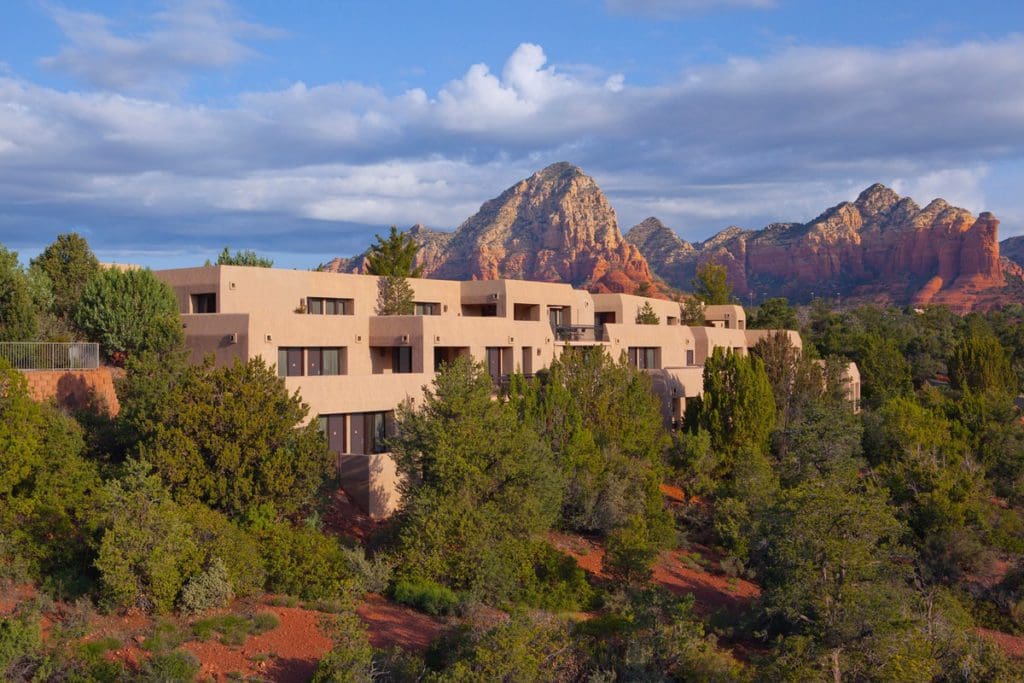 Sky Rock Sedona nestled in the trees with Sedona's iconic red rocks in the distance.