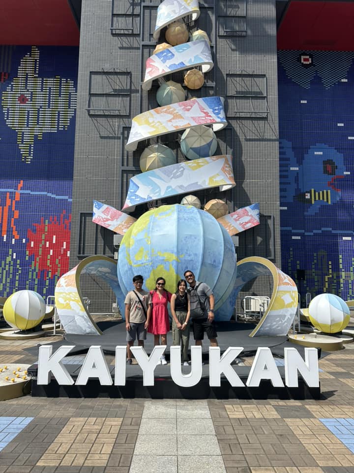 A family stands in front of the entrance to the aquarium in Osaka.