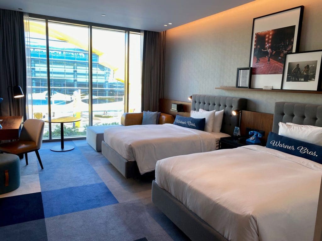 Inside a double Queen guestroom at WB Abu Dhabi, Curio Collection by Hilton, the best place to stay during your family trip to Yas Island in Abu Dhabi.