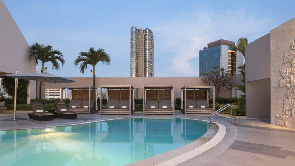 The outdoor pool and pool deck at Four Seasons Hotel Singapore, one of the best hotels in Singapore with kids.