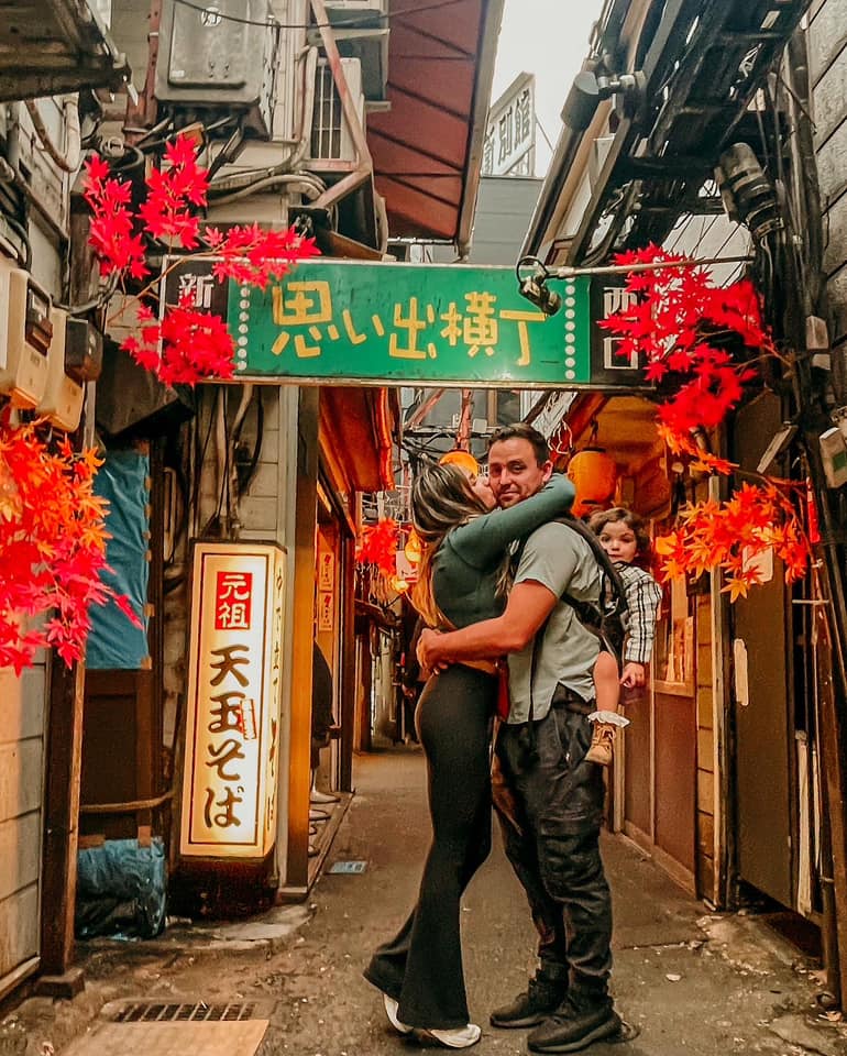 A family stands together in the middle of a cozy street in Tokyo.