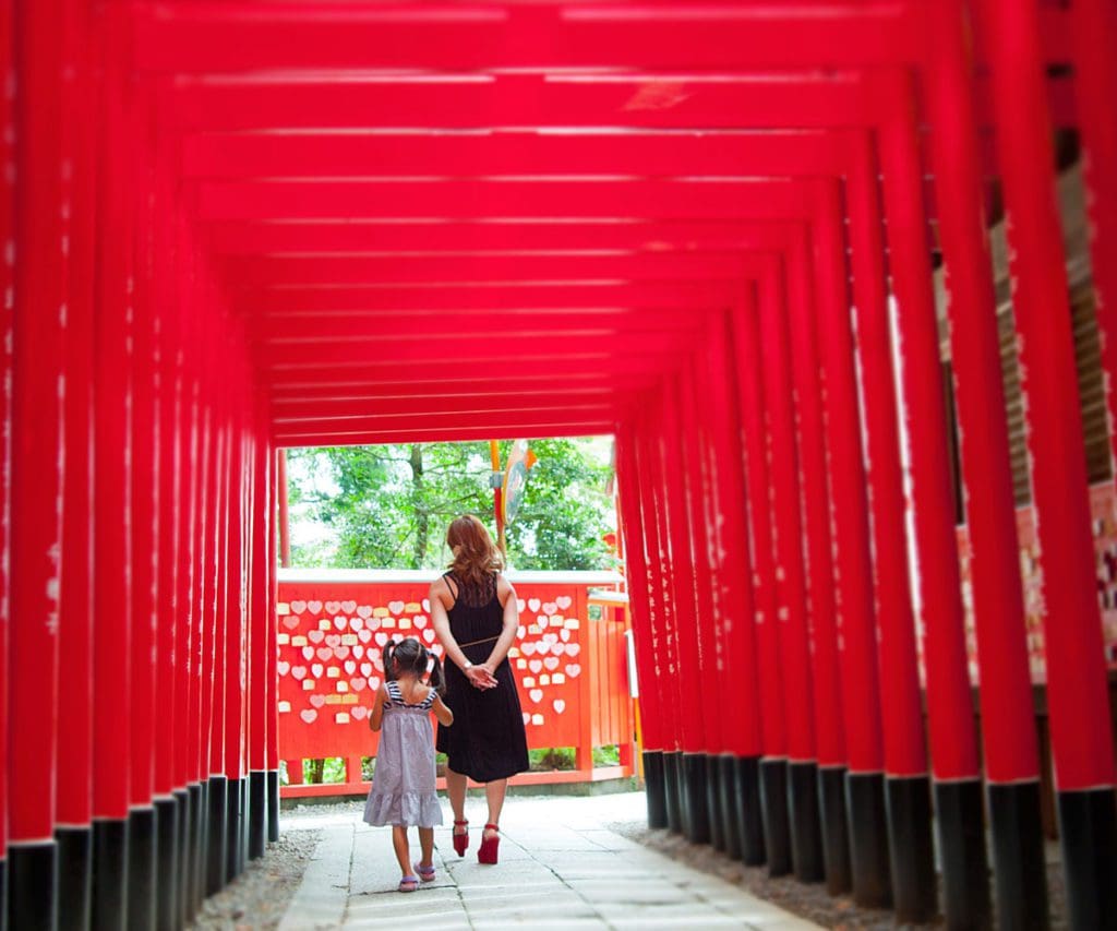 A mother and her daughter walk through Senbon Torii in Tokyo.