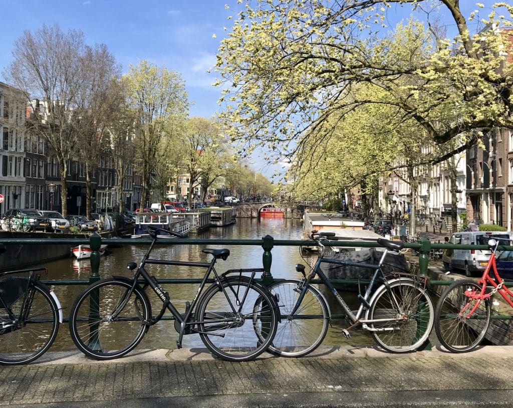 A bike resting against a bridge over a canal in Amsterdam.