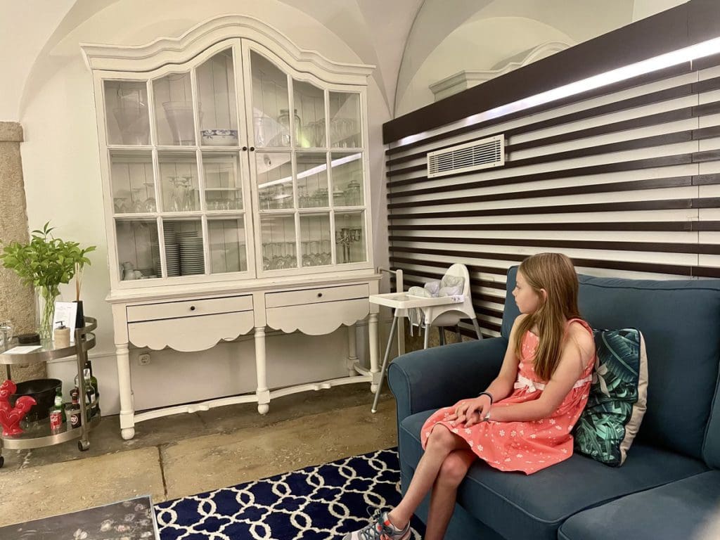 A young girl sits comfortably in the hotel lobby of Alecrim ao Chiado - Once Upon a House.