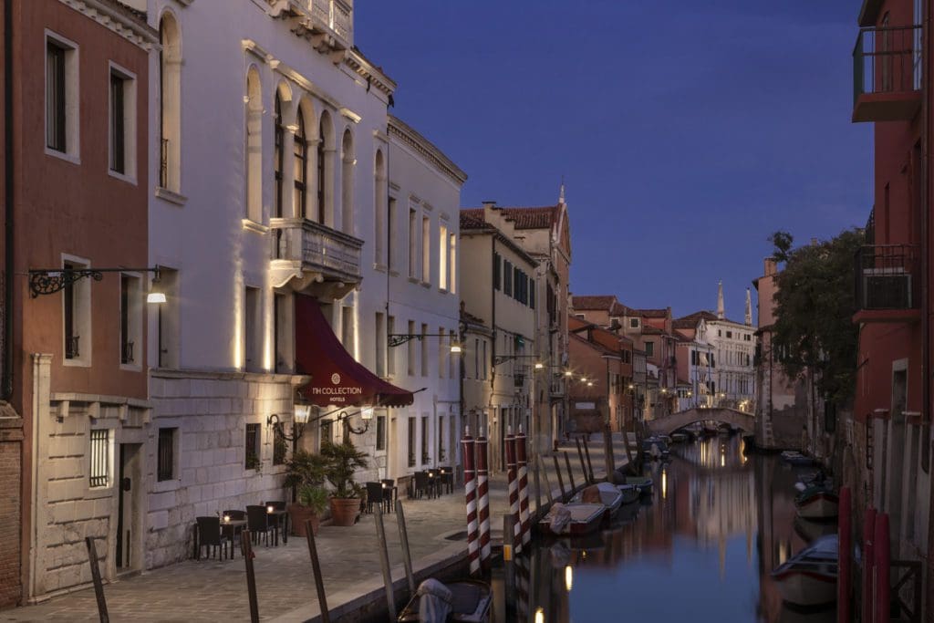 The entrance to NH Collection Venezia Grand Hotel Palazzo dei Dogi along a canal at night.