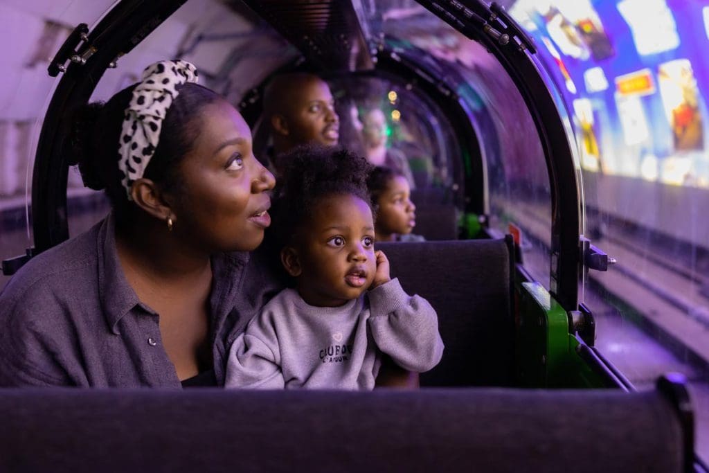 A mom and her young daughter enjoy an exhibit at The Postal Museum.