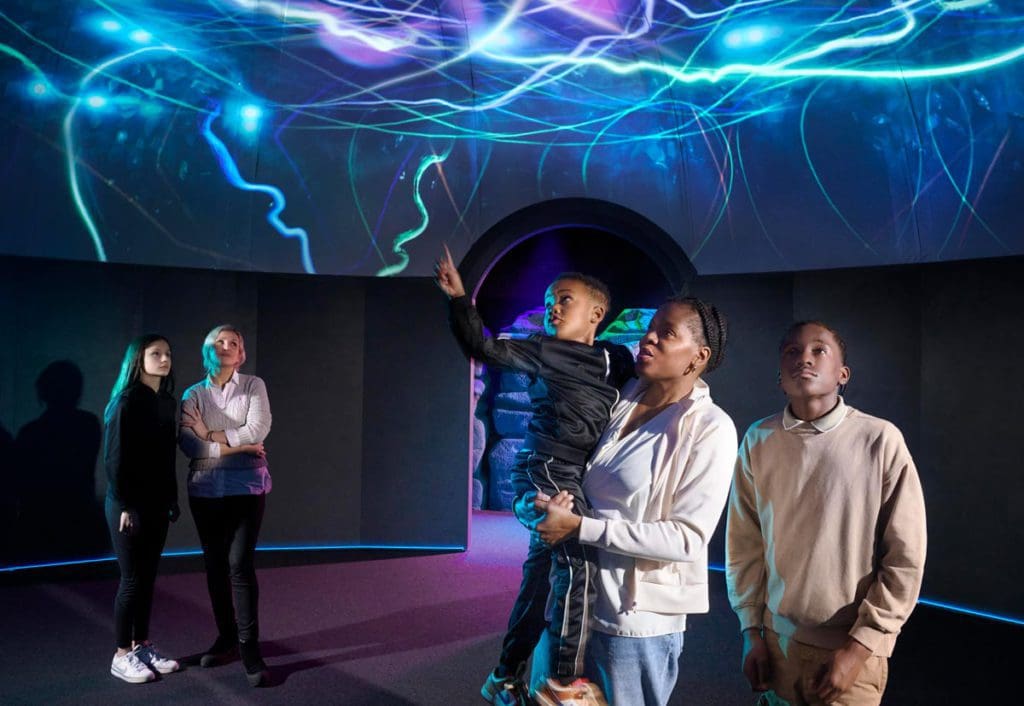 A family enjoys a fun exhibit at the Science Museum in London.