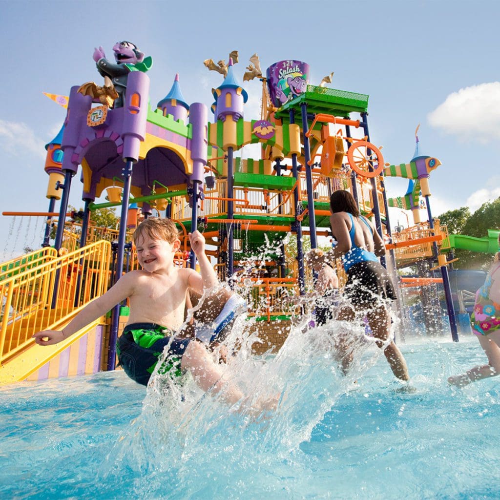 Kids splash and play at an outdoor water splash area at Sesame Place.
