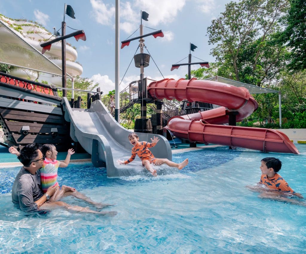 A family plays in the on-site water slide at Shangri-La Singapore, one of the best hotels in Singapore with kids.