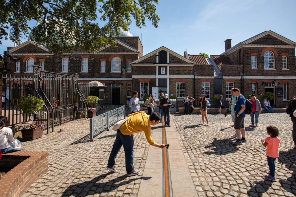 People crowded around the Prime Meridian at Royal Observatory Greenwich, one of the best museums in London for kids.