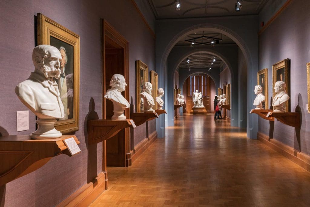 Several busts line the hallway of a gallery at The National Portrait Gallery.