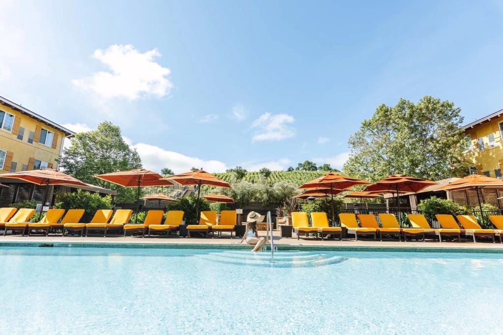 A woman sits at the edge of the outdoor pool on a sunny day at Meritage Resort & Spa in Napa.