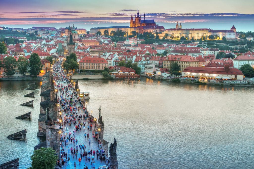 People cross the pedestrian bridge in Prague, one of the best international destinations for teens interested in history.