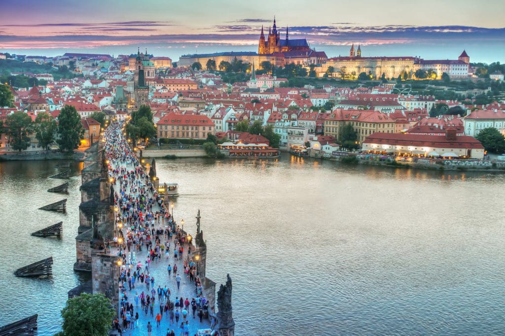 People cross the pedestrian bridge in Prague.