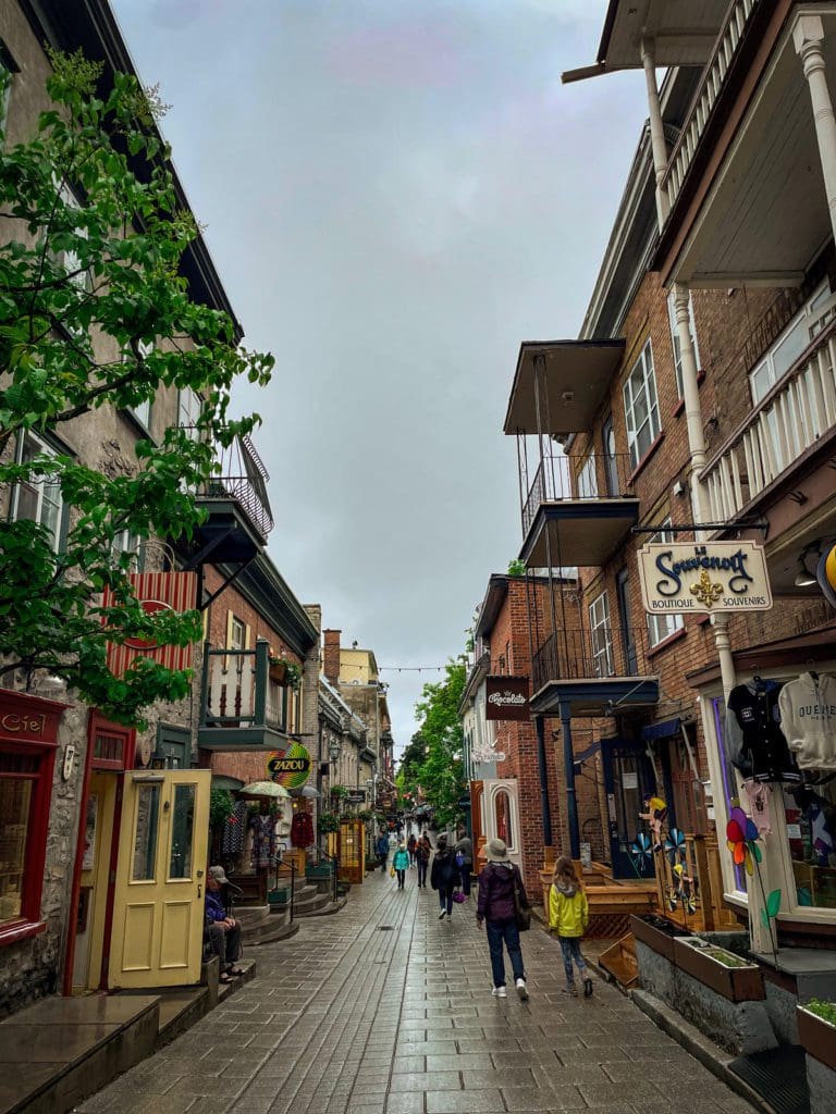 A grandmother and her granddaughter walk down a street in Old Quebec.