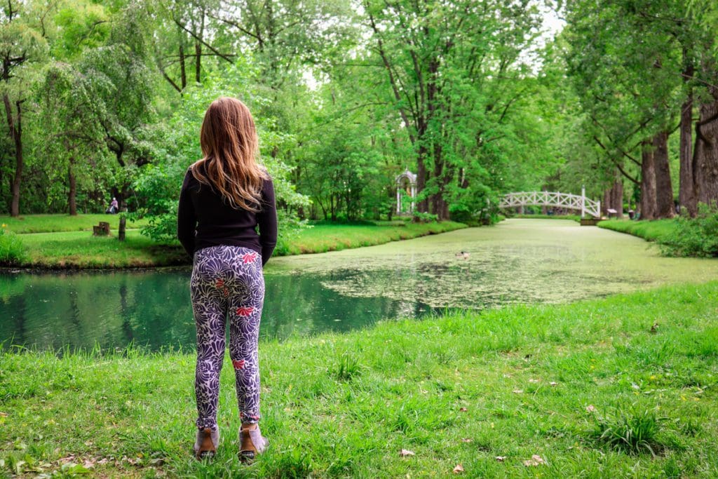 A young girl stands and watches the ducks in the pond at Domaine de Maizerets, a must do on any Quebec City itinerary with kids.