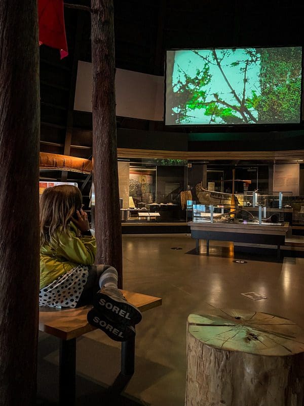 A young girl listens to an audio guide at the Huron-Wendat Museum.