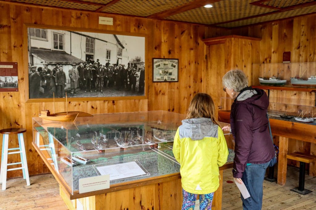 A grandmother and her granddaughter look at a museum exhibit at Parc Maritime de Saint-Laurent, a must do on any Quebec City itinerary with kids.