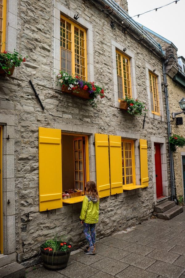 A young girl looks in a shop window, while strolling down a street in the Petit Champlain Quarter.