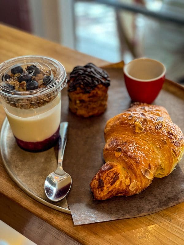 A morning breakfast spread from Maison Smith, including coffee and a large croissant, a must eat on any Quebec City itinerary with kids.