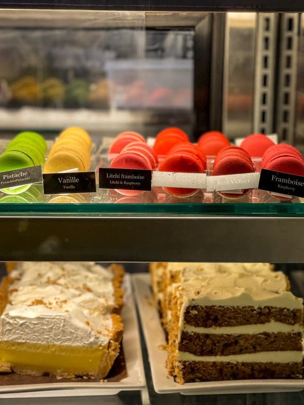 Several desserts in a display case at Maison Smith, including colorful macrons and cakes.