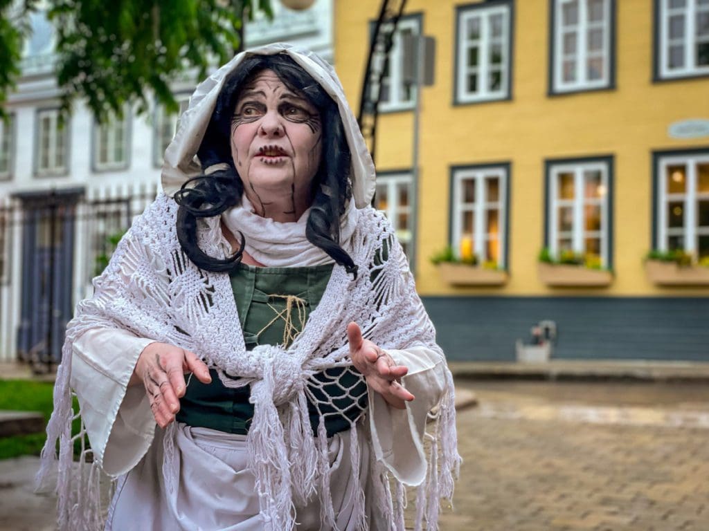 A tour guide on a Les Promenades Fantômes' Walks with Ghosts in Old Quebec spins a tale of criminals from the early years of New France, a must do on any Quebec City itinerary with kids.