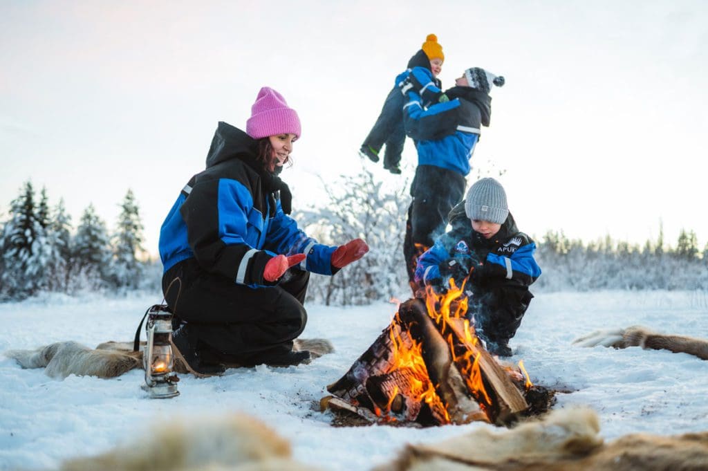 A family builds a fire at Apukka Resort.
