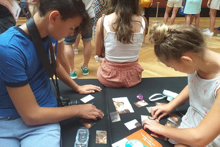 Kids work at a riddle, while on the Family Treasure Hunt at the Louvre Museum.
