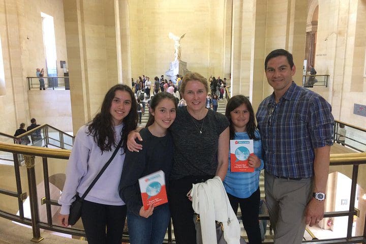 A family poses together while on the Family Treasure Hunt at the Louvre Museum.