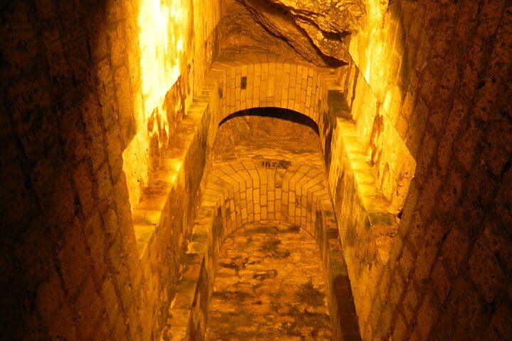 Inside the catacombs on the Fast Access Paris Catacombs and City Highlights Tour for Kids and Families .