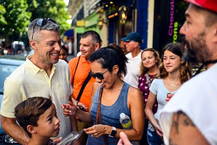 Families enjoy treats on a Paris street, while on a Paris Chocolate and Pastry Private Tour with Secret Food Tours.