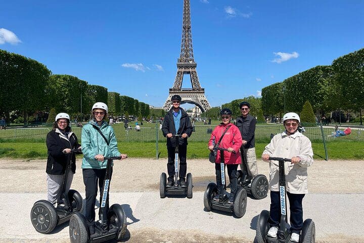 A family of five, all atop segways in front of the Eiffel Tower, while on a Paris City Sightseeing Half-Day Guided Segway Tour with a Local Guide.