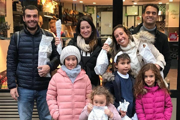 A family poses outside a bakery during the Paris French Bakery Behind the Scenes Experience.