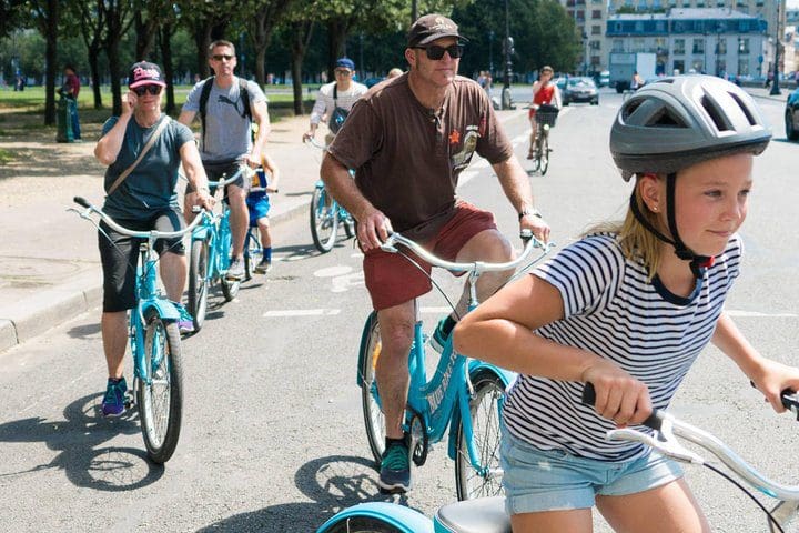 A family tours Paris on bicycle with the Paris Highlights Bike Tour with Eiffel Tower, Louvre, and Notre Dame.